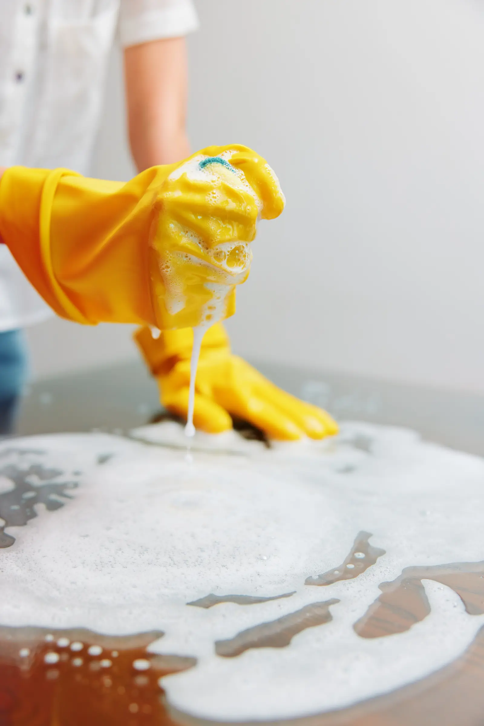 Scrubbing a wooden table with soapy water